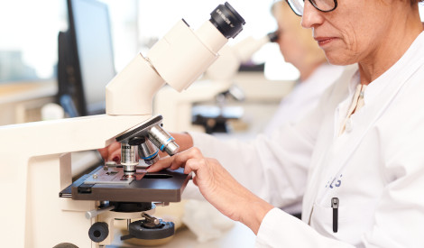 Wissenschaftliche Mitarbeiterin des UMG-Labors platziert einen Objektträger unter dem Mikroskopu